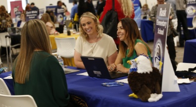  Employers at job fair interviewing candidate.